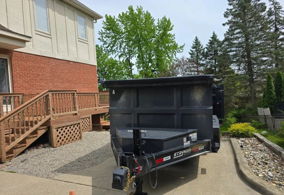 Trailer on driveway by wooden steps.